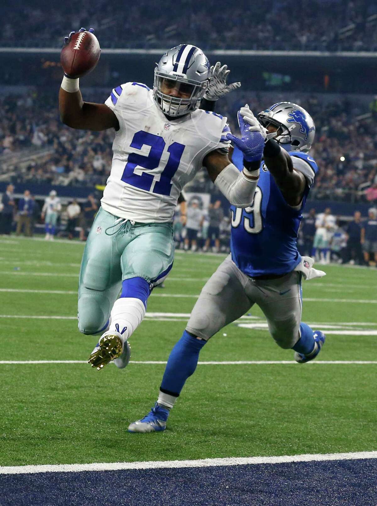 Dallas Cowboys' Ezekiel Elliott (21) leaps into the end zone after getting past Detroit Lions' Tahir Whitehead, rear, for a touchdown in the second half of an NFL football game, Monday, Dec. 26, 2016, in Arlington, Texas. (AP Photo/Michael Ainsworth)