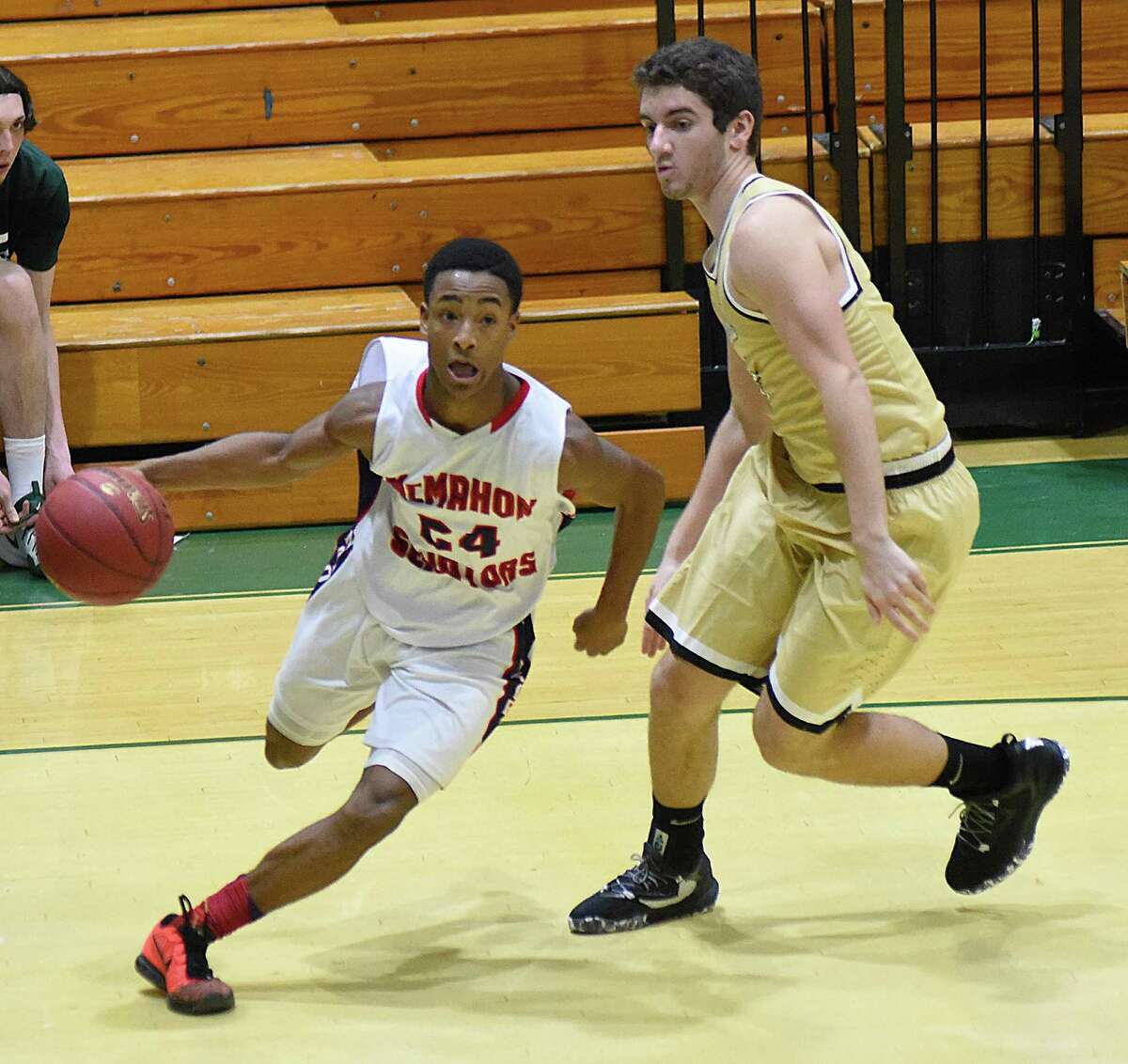Brien McMahon’s Eric Day, left, races past Joel Barlow defender Phil Villhauer during the second half of Tuesday’s Holiday Basketball Tournament game, hosted by Norwalk High at Scarso Gym in Norwalk.