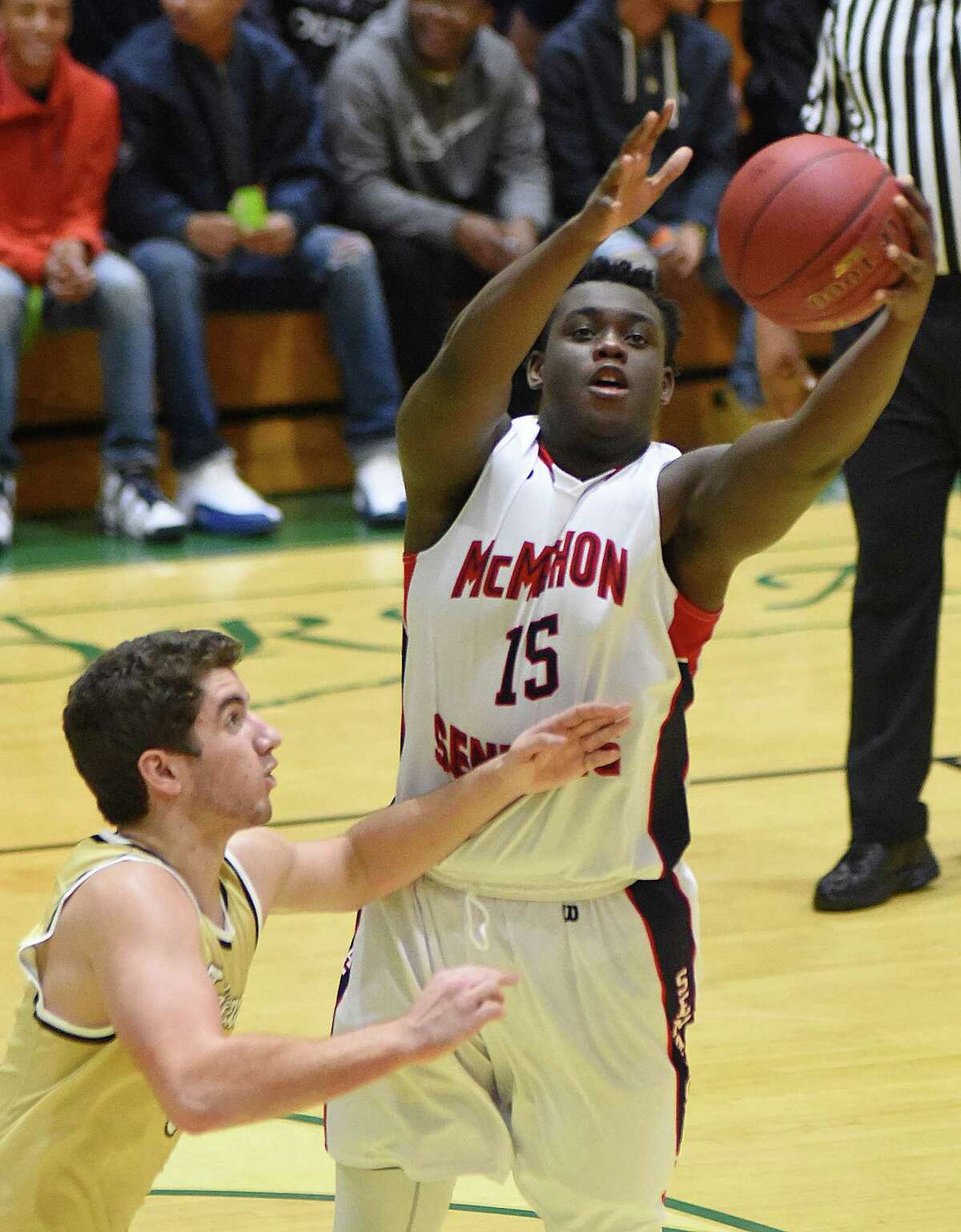 Brien McMahon’s Saikwon Williams, right, reaches for a long rebound during Tuesday’s Holiday Tournament game against Joel Barlow, hosted at Norwalk High’s Scarso Gym.
