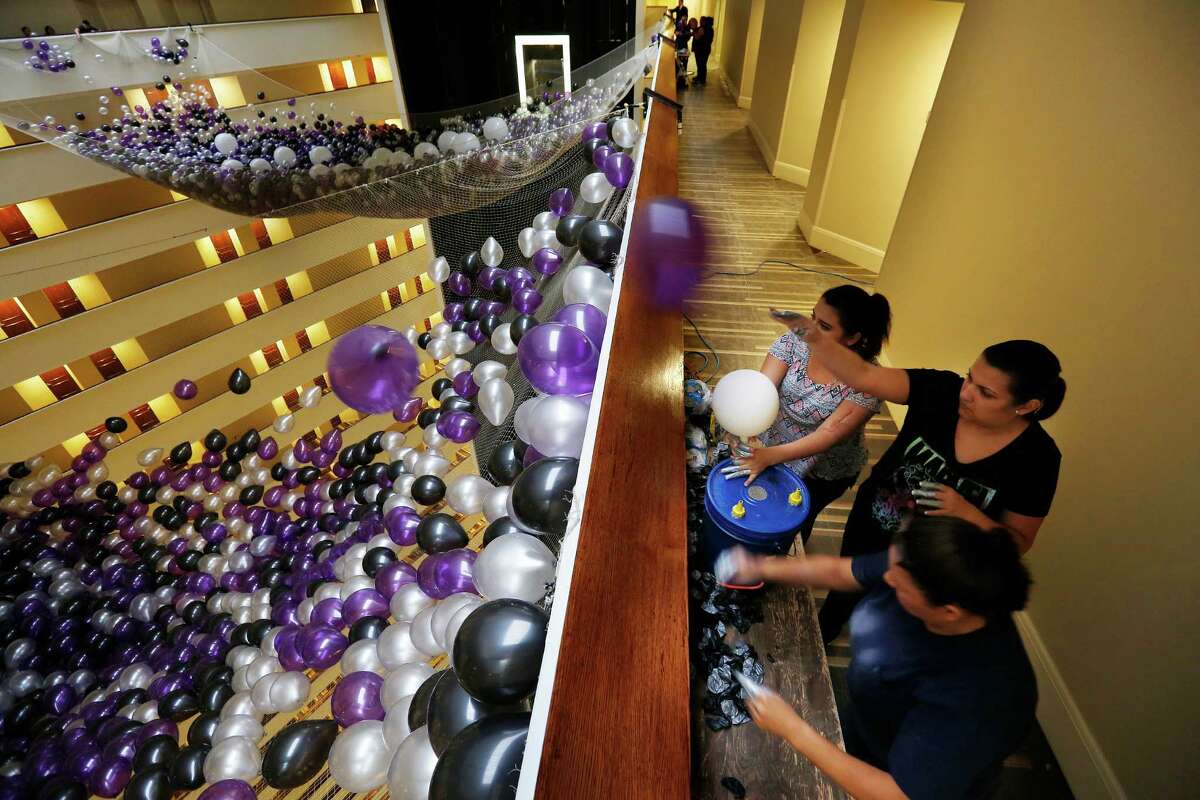 Oralia Valdez (bottom), Maria Garcia (middle) and Danyelle Valdez (top), with Fantastic Balloons, fill one of two giant nets with over 50,000 balloons for the Hyatt Regency Houston hotel's annual New Year's Eve party and balloon drop, Wednesday, Dec. 30, 2015, in Houston. ( Mark Mulligan / Houston Chronicle )