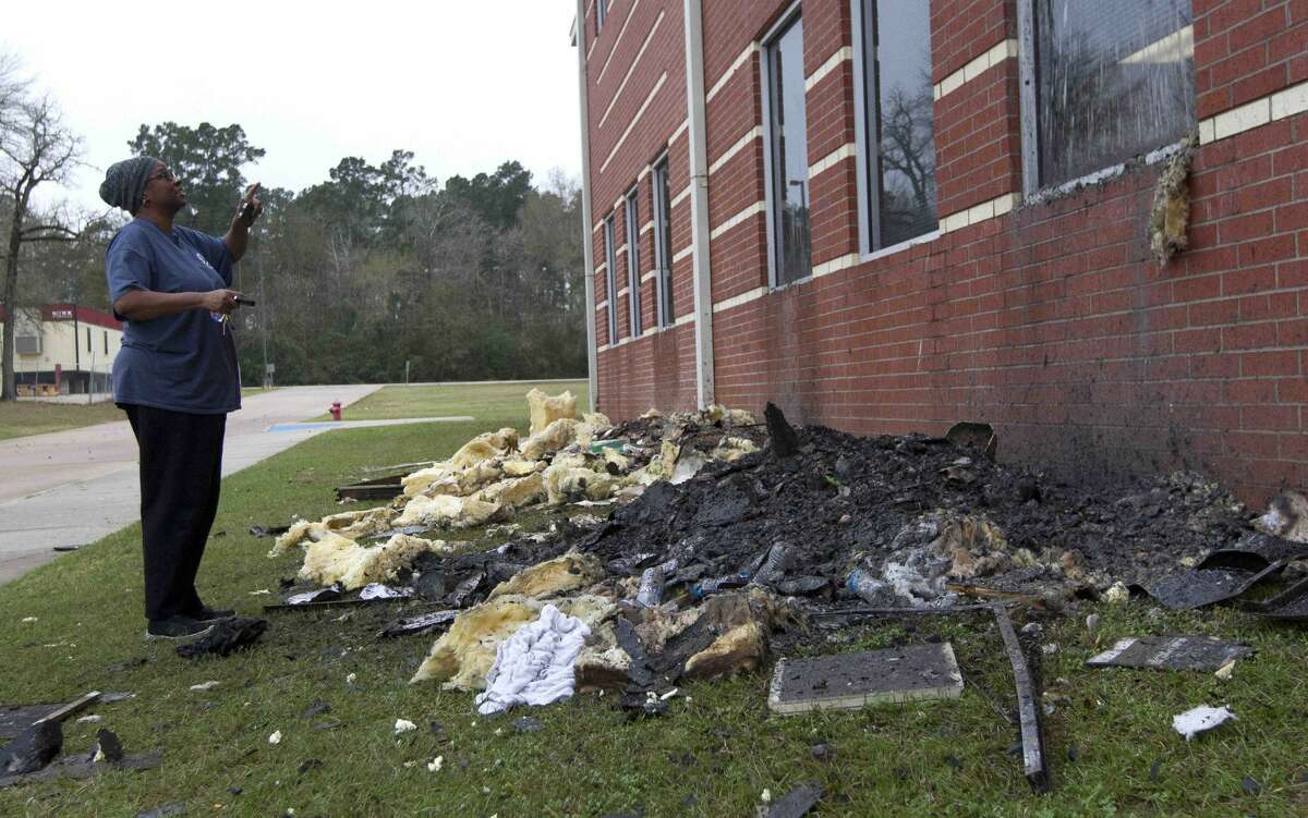 A woman surveys a damaged section of Bear Branch Junior High School after a fire broke out around 12:20 a.m. Wednesday, Dec. 28, 2016, in Magnolia.