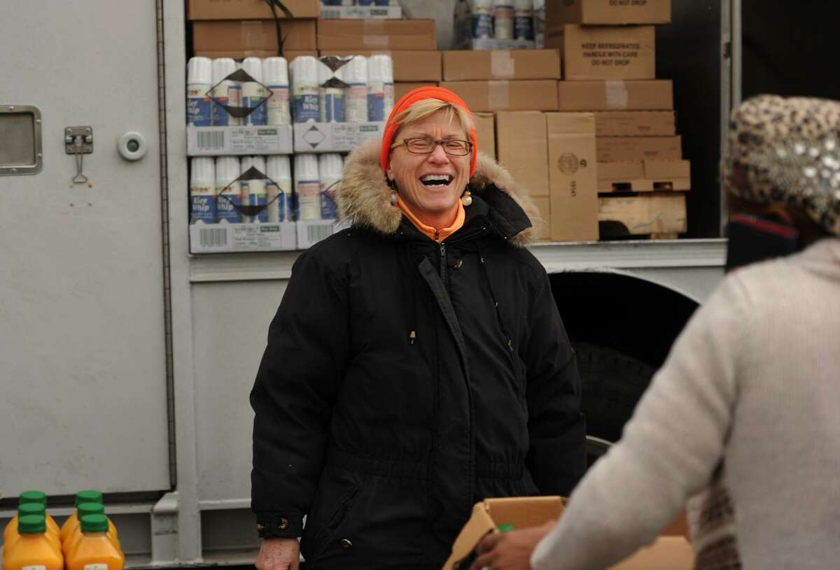 Volunteer Carol Wolf, of Easton, laughs with customers at the Monthly Mobile Food Pantry on Jane Street in Bridgeport, Conn. on Wednesday, December 28, 2016. The pantry is staffed by three groups of volunteers making up The Emmaus Partnership.