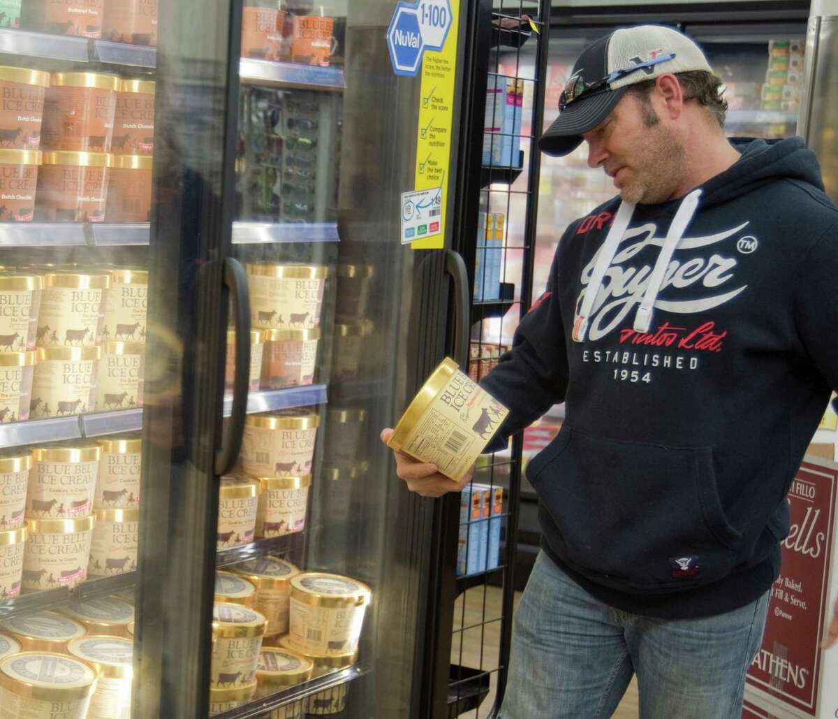 Steve Morris decides on a tub of Homemade Vanilla Blue Bell Monday 12-14-2015 after the ice cream was restocked on Midland shelves early Monday at Market Street. Tim Fischer\Reporter-Telegram