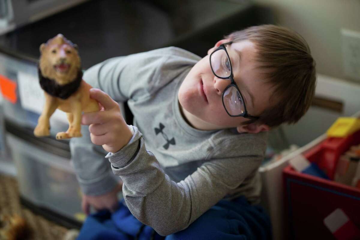 Sam Bullion, 10, plays with animal toy figures at his home in Austin. Bullion was born with Down syndrome, but his mother had to struggle to get him into special education.