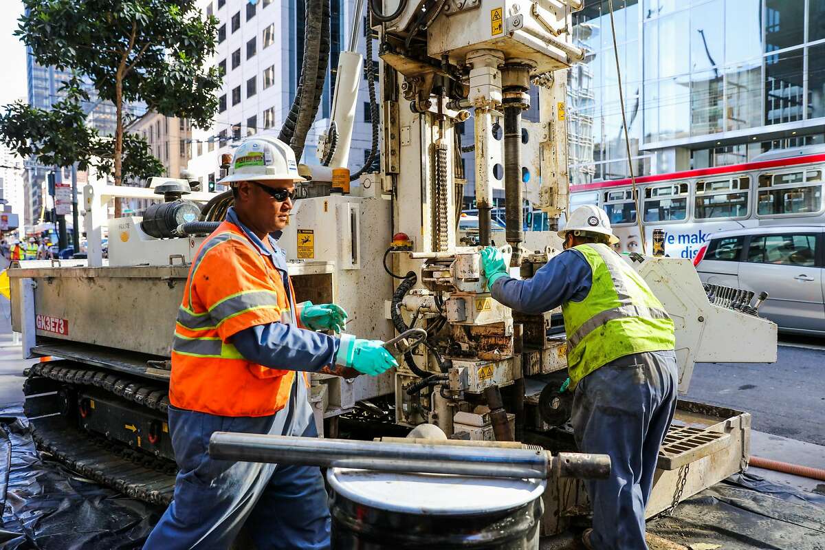 Workers Will Halai and Malakai Fakalolo (right) use a Fraste machine while doing tests soil levels outside the Millennium Tower, a residential building which is leaning, in San Francisco, California, on Monday, Sept. 26, 2016.