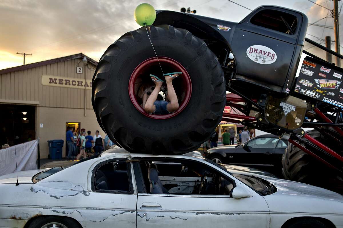 BRITTNEY LOHMILLER | blohmiller@mdn.net Eight-year-old Peyton Hickerson of Midland climbs into one of the four monster truck tires on display at the Midland County Fairgrounds Tuesday evening.