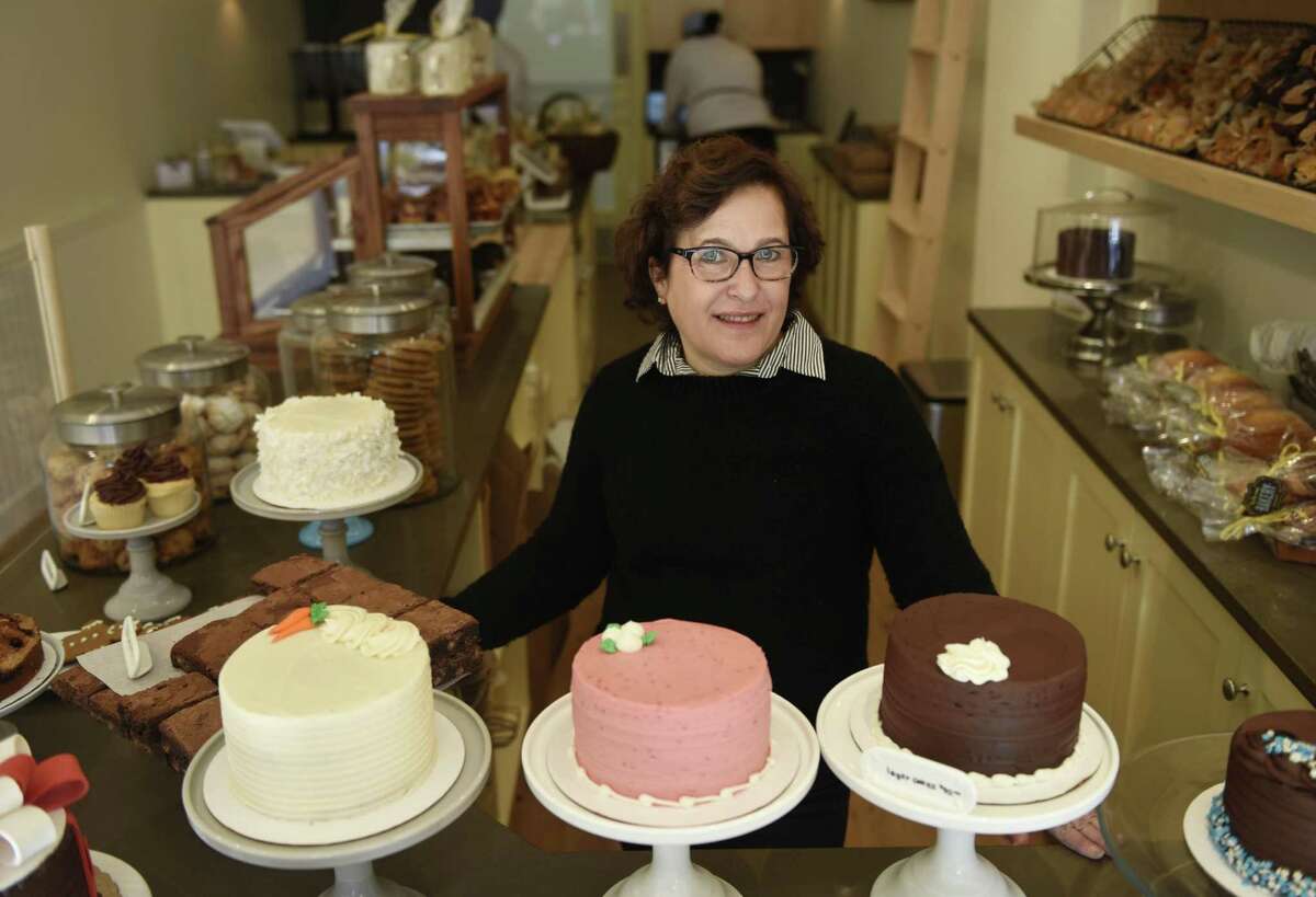 Owner Helene Godin poses behind the counter at By the Way Bakery in Greenwich, Conn. Wednesday, Dec. 21, 2016. Located at 19 E. Putnam Ave., the bakery opened Wednesday and serves a variety of pastries, cakes and other baked goods, as well as Stumptown coffee from Portland, Ore.