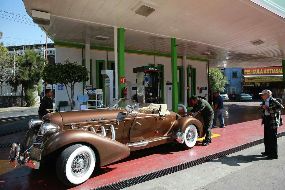 A Pemex employee fuels up a classic convertible at a station in Mexico City. Mexico will raise gasoline prices by as much as 20 percent in January, stoking inflation that's already running at the fastest pace in almost two years.