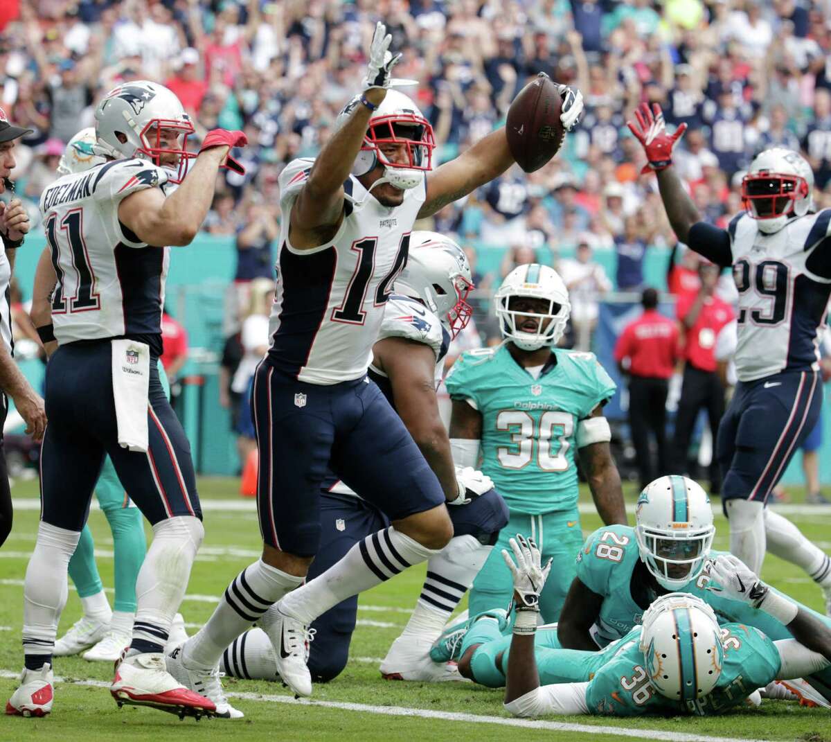 New England Patriots wide receiver Michael Floyd (14) celebrates his touchdown, during the first half of an NFL football game against the Miami Dolphins, Sunday, Jan. 1, 2017, in Miami Gardens, Fla. (AP Photo/Lynne Sladky)