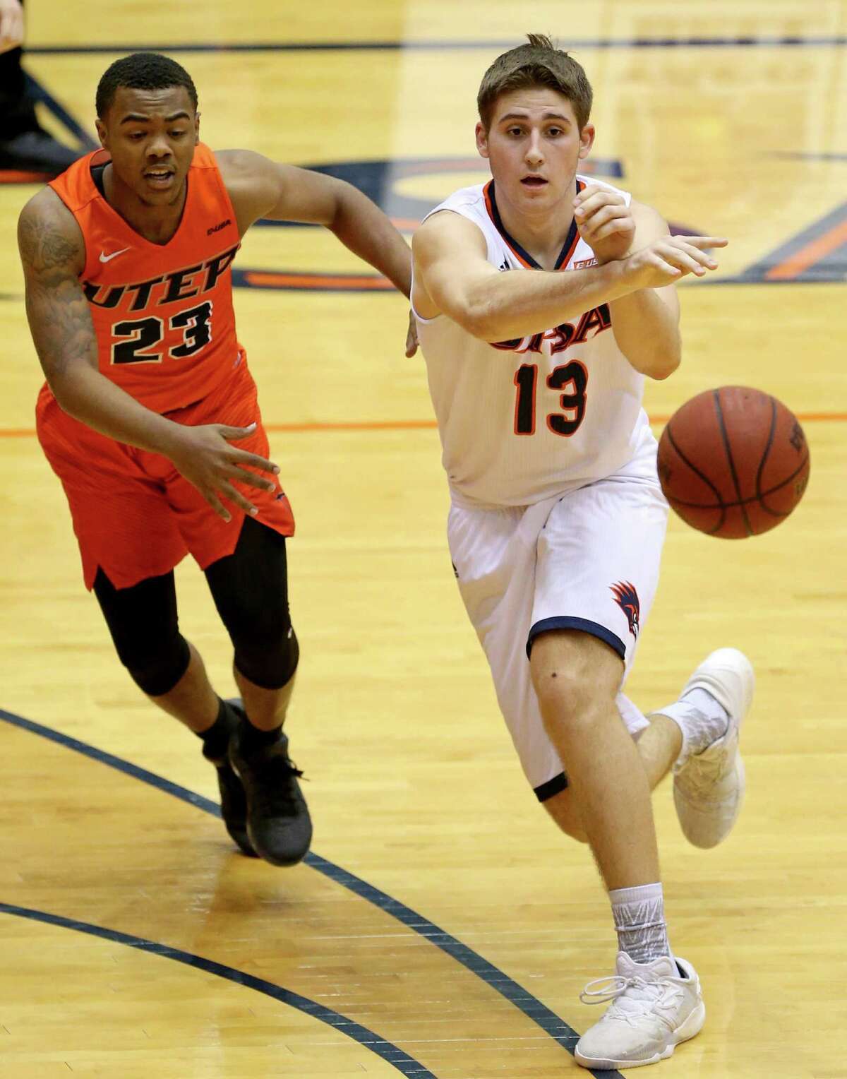 UTSA's Byron Frohnen passes around UTEP's Deon Barrett during first half action Sunday Jan. 1, 2017 at the Convocation Center.