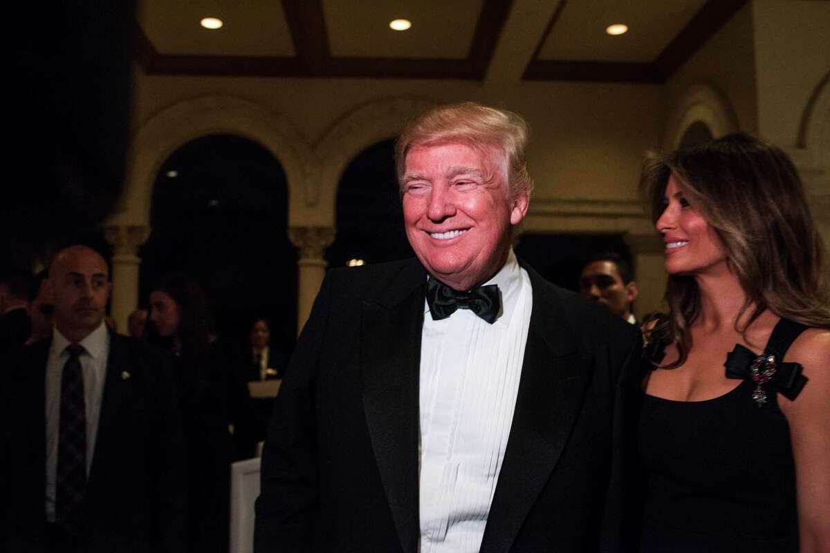 President-elect Donald Trump and his wife, Melania, speak with reporters at his New Year's Eve party in the ballroom at the Mar-a-Lago resort.