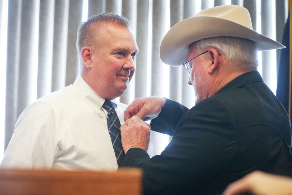 Outgoing sheriff Tommy Gage pins the badge on newly sworn in sheriff Rand Henderson during the Montgomery County Ceremony to Administer Oath of Office on Sunday, Jan. 1, 2017, at the Lone Star Convention Center.