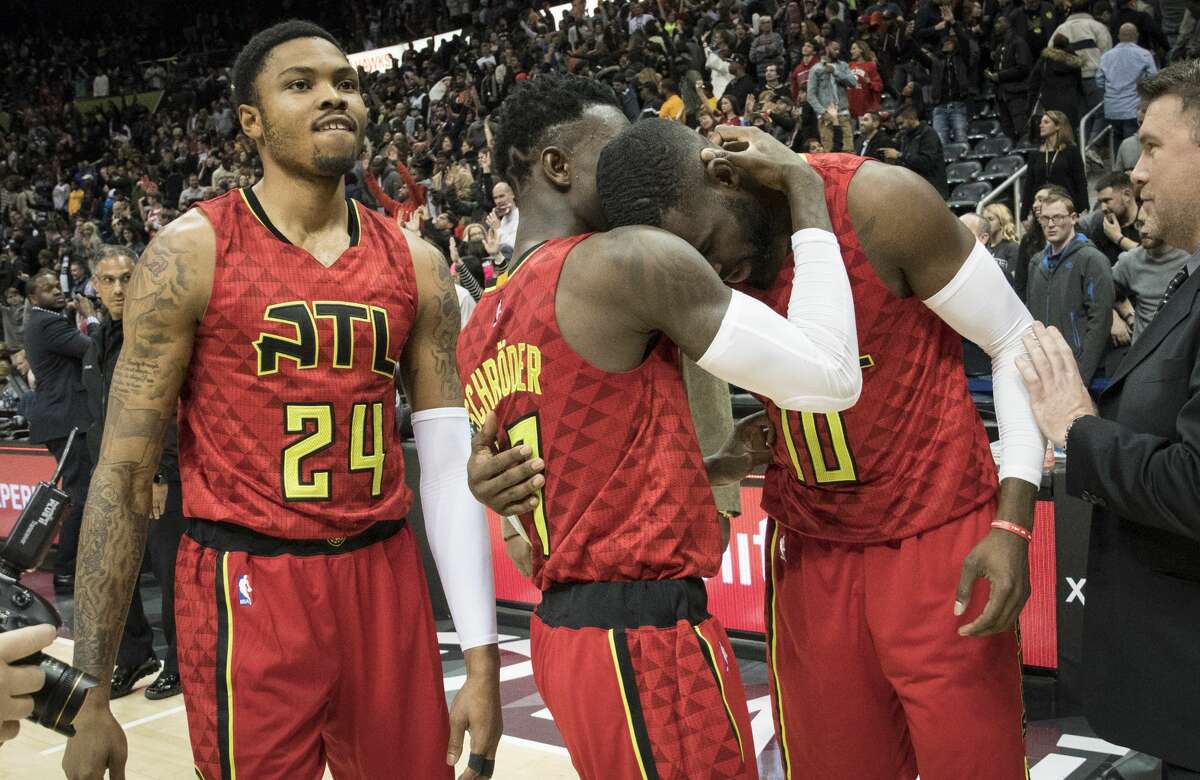 Atlanta Hawks guards Tim Hardaway Jr. (10) and Dennis Schroder, of Germany, congratulate each other as forward Kent Bazemore (24) watches after the team's NBA basketball game against the San Antonio Spurs, Sunday, Jan. 1, 2017, in Atlanta. Atlanta won 114-112 in overtime. (AP Photo/John Amis)
