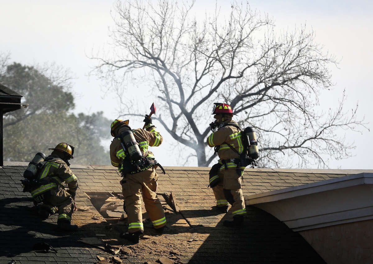 Conroe firefighters carve a hole in the roof to vent smoke and heat on Monday, Jan. 2, 2017, after a fire broke out at the Saltgrass Steak House off of Interstate 45 North in Conroe.