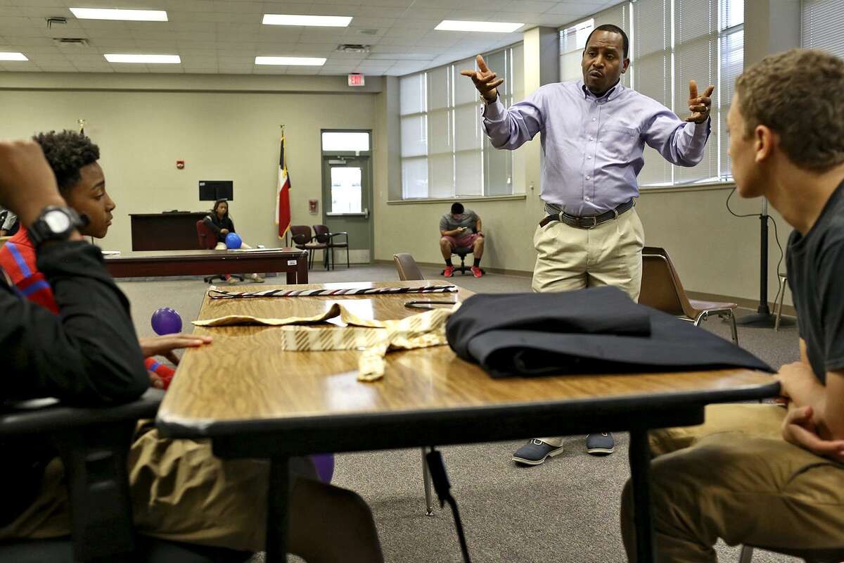 Walter Perry teaches boys how to interact in professional settings during SUIT UP!, a business and professional clothing program created by Perry, at the former Pfeiffer Elementary School on Oct. 25, 2016.