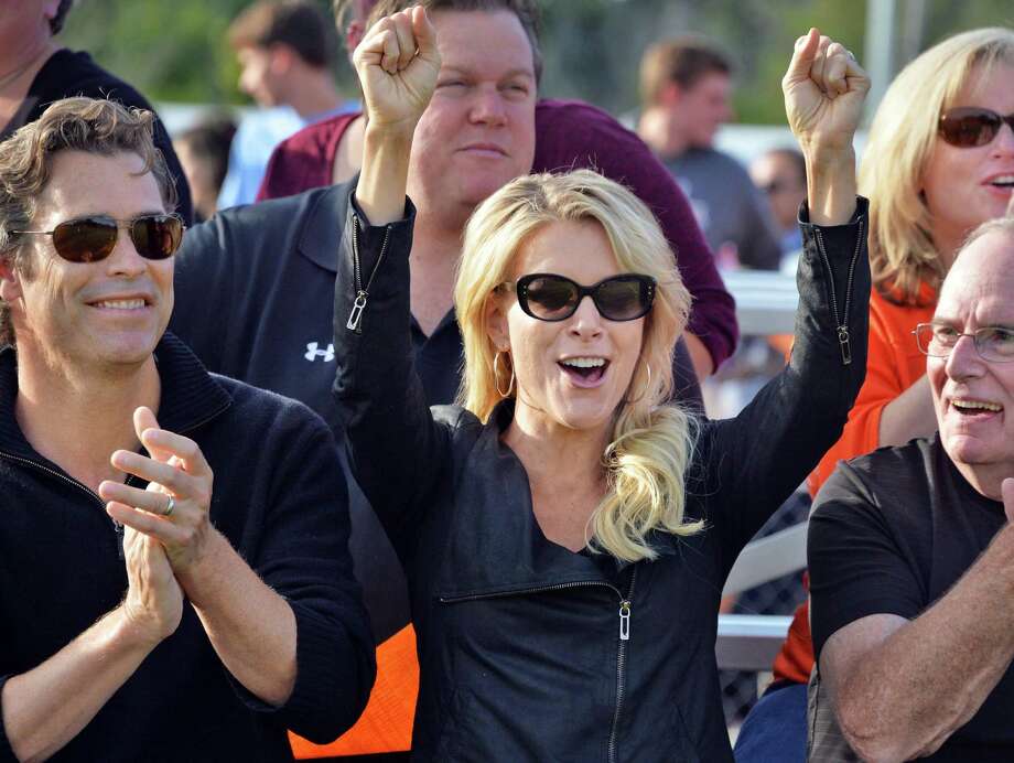 Megyn Kelly, de Fox News, membre de la classe BCS de 88 ans, félicite le touché par son équipe avant une cérémonie d’intronisation au Temple de la renommée à la mi-temps à la Bethlehem Central High School le samedi 26 septembre 2015 à Bethlehem, NY. À gauche, le mari de Megyn, le romancier Doug Brunt. (John Carl D'Annibale / Times Union) Photo: John Carl D'Annibale / 00033505A