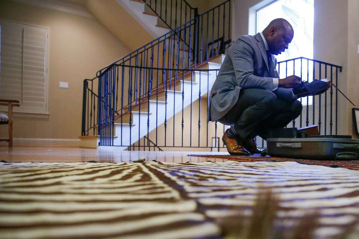 Established Bespoke owner Gary Warfield looks through fabric samples to show to his client, Kevin Jones, at Jones' home Saturday, Dec. 31, 2016 in Houston. Warfield's company makes house calls to fit clients clothes. ( Michael Ciaglo / Houston Chronicle )