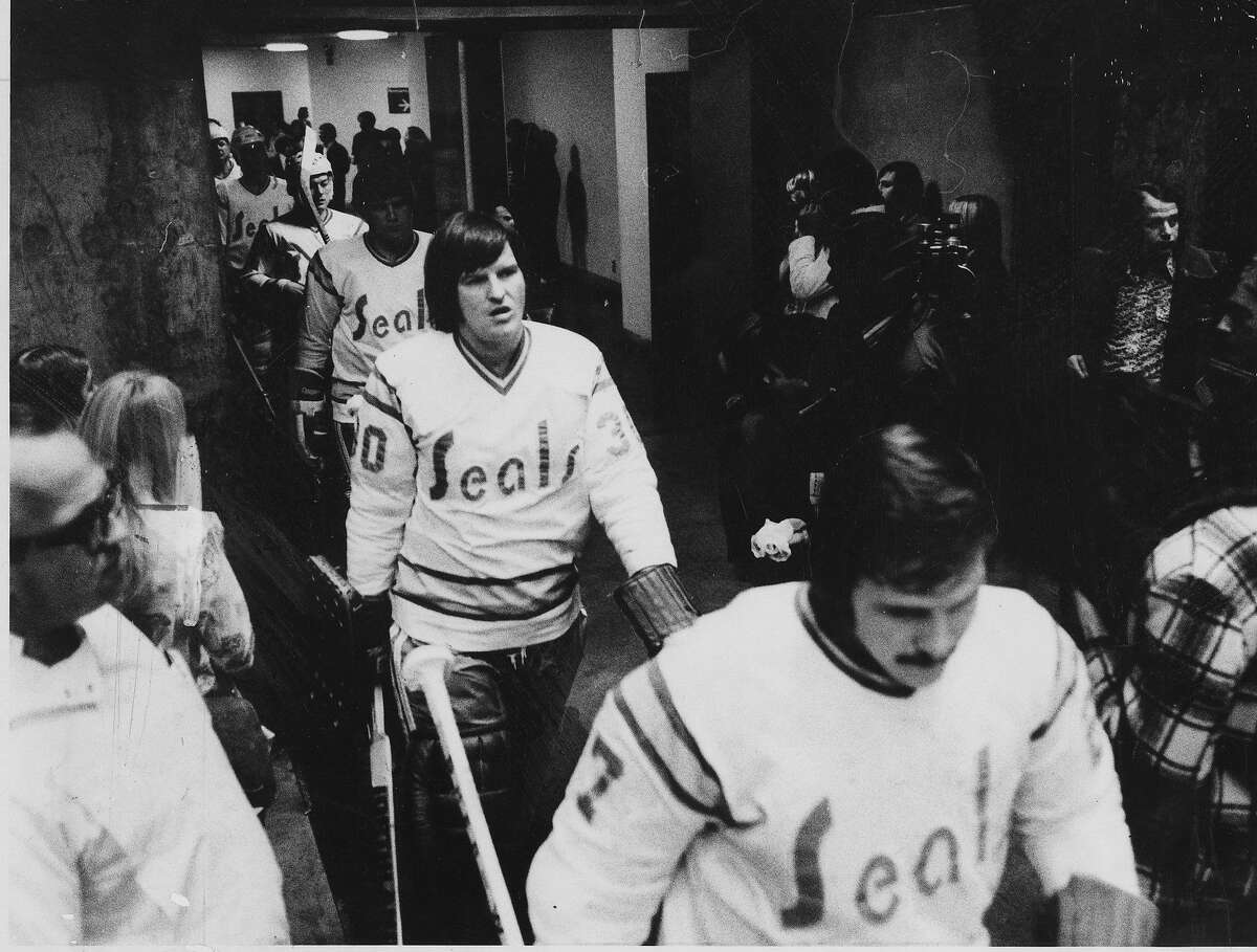 California Golden Seals head for the Ice at the Oakland Arena leading the way are Gary Simmons (l) and Gilles Miloche, Photo ran 12/20/1974, p. 63