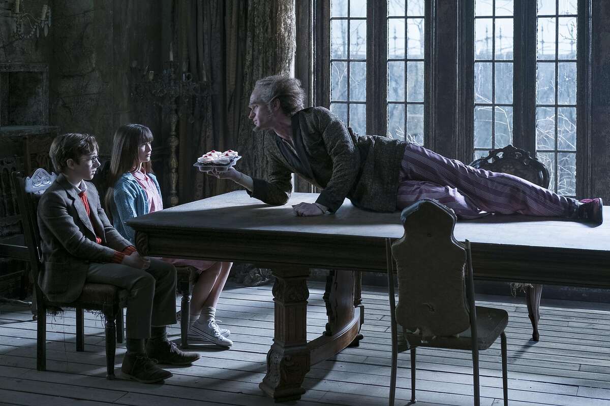 Neil Patrick Harris gives the character of Count Olaf his sinister best as he illustrates as he viciously crawls down tne table to inform the horrified Baudelaire orphans of his latest scheme in 'A Series of Unfortunate Events' on Netflix.