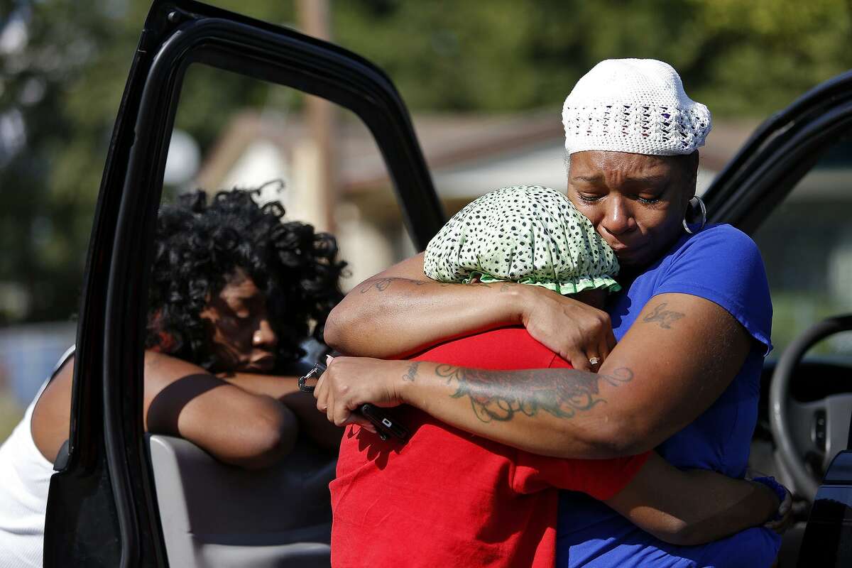 Jillian Peterson embraces Shavonne Ferguson, 15, at the placed where a young man was shot and killed and another was injured in San Antonio on Sept. 26, 2015. The women believed the victim to be their friend, Tru Trusty, 16.