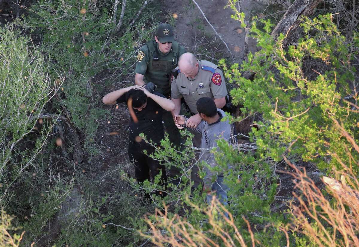 MCALLEN, TX - OCTOBER 18: A Texas state trooper and a U.S. Border Patrol agent detain undocumented immigrants on October 18, 2016 near McAllen, Texas. Immigration and border security have become major issues in the American Presidential campaign. (Photo by John Moore/Getty Images) *** BESTPIX ***