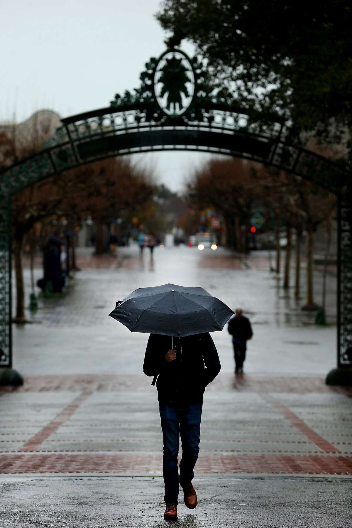 Dallin Jackson, a UC Berkeley student in his senior year, make his way past Sather Gate during a rainy day at UC Berkeley on Wednesday, Jan. 4, 2017 in Berkeley, Calif. Tuition at the University of California is expected to grow for the first time since 2011 under a proposal the UC regents will consider this month.