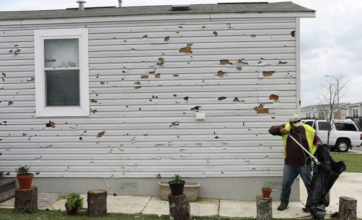 A residentpicks up debris at the Woodlake Estates following a severe hailstorm in April. HB1774 would protect consumers from storm-chasing lawyers exploiting natural disasters.