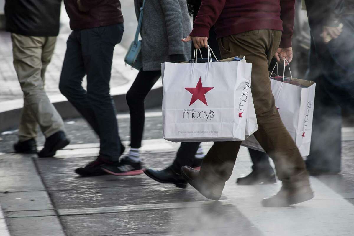 A shopper carries Macy's Inc. shopping bags in San Francisco, California, U.S., on Monday, Dec. 26, 2016. The Bloomberg Consumer Comfort Index, a survey which measures attitudes about the economy, is scheduled to be released on December 29. Photographer: David Paul Morris/Bloomberg