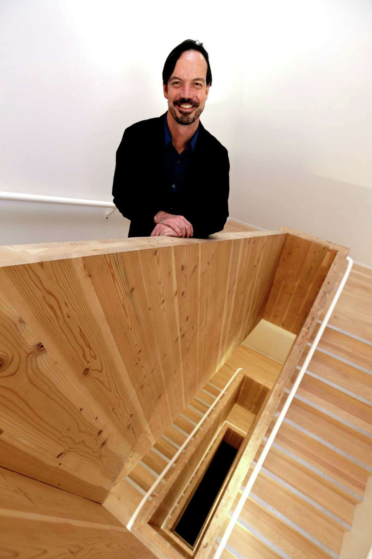 In this Nov. 15, 2016, photo, Lever Architecture founder Thomas Robinson poses for a photo in his company's all-wood headquarters building, built with cross-laminated timber, or CLT, in Portland, Ore. Lever Architecture is about to break ground on a 12-story all-wood building, using CLT, in Portland's Pearl District that the company says will be the tallest all-wood building in the world in a seismic zone and the tallest all-wood building in North America. (AP Photo/Don Ryan)