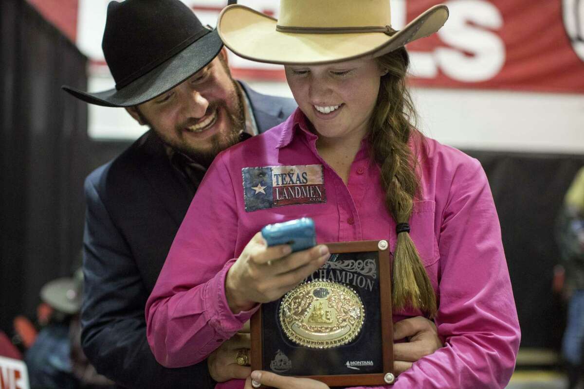 Callie duPerier and her fianc Kaleb Apffel look at Callie's phone, which was buzzing with congratulatory messages, after Callie won the World Championship in Barrel Racing at the Wrangler National Finals Rodeo in Las Vegas, Nevada on December 12, 2015. She wore the same pink shirt, socks and jeans for six nights in a row, because she thought they brought her good luck. "I am really superstitious," Callie said.