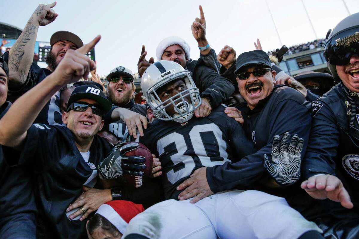 Raiders fans surround player Jalen Richard (#30) after the Raiders scored a touchdown in the first half of a game between the Oakland Raiders and the Indiana Colts, in Oakland, Calif., on Saturday, Dec. 24, 2016.