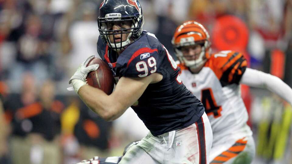 Houston Texans defensive end J.J. Watt (99) returns an interception 29 yards for a touchdown as Cincinnati Bengals quarterback Andy Dalton (14) gives chase to give the Texans the lead during the second quarter of an AFC wildcard playoff football game at Reliant Stadium on Saturday, Jan. 7, 2012, in Houston. ( Karen Warren / Houston Chronicle )