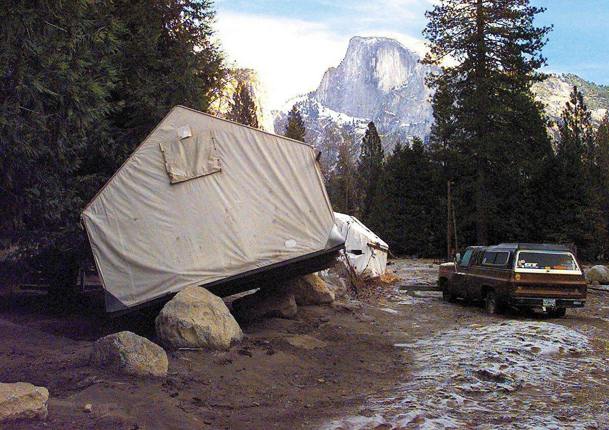 Tent cabins used by the concession workers were tossed around by New Years Day flood waters and landed in various places throughout the Yosemite Valley floor. Half Dome looms above.