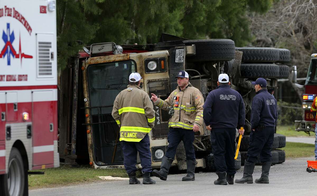 San Antonio firefighters work Wedesday January 4, 2017 at the intersection of Boxwood and Bonair on the city' South East Side where a garbage truck rolled over spilling trash and puncturing a fuel tank. The driver was treated at the scene by EMS and the fire department's hazardous material team was called to clean up the spilled diesel fuel. The accident took place at about 11:15 a.m..