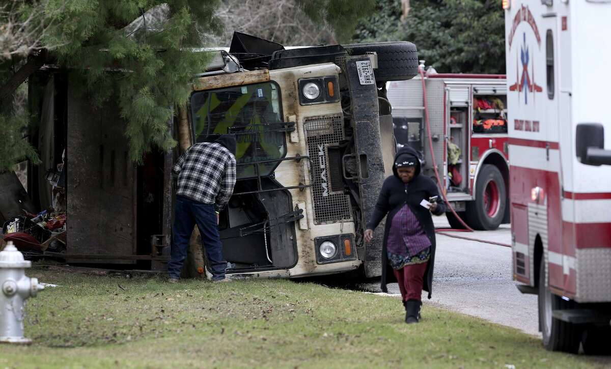 San Antonio firefighters work Wedesday January 4, 2017 at the intersection of Boxwood and Bonair on the city' South East Side where a garbage truck rolled over spilling trash and puncturing a fuel tank. The driver was treated at the scene by EMS and the fire department's hazardous material team was called to clean up the spilled diesel fuel. The accident took place at about 11:15 a.m..