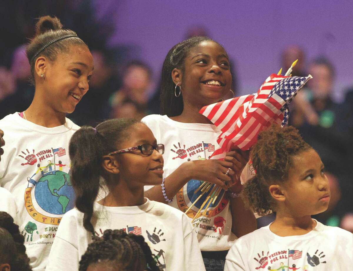 Members of the Children's Mass King Choir smile after performing 'America the Beautiful' during the annual commemorative celebration honoring Dr. Martin Luther King Jr. in The Woodlands Monday.