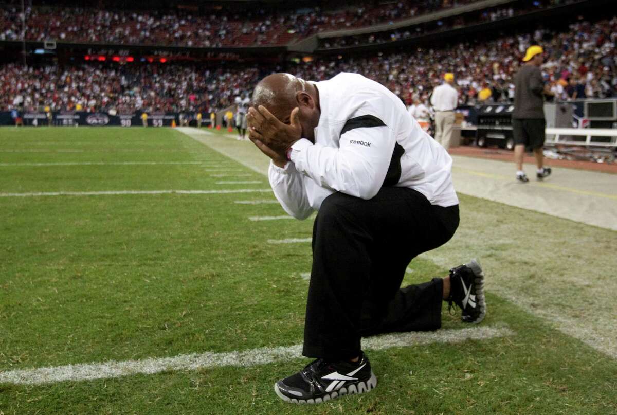 Coach Hue Jackson kneels on the field overcome with emotion after his Raiders beat the host Texans the day after Oakland owner Al Davis died in 2011.