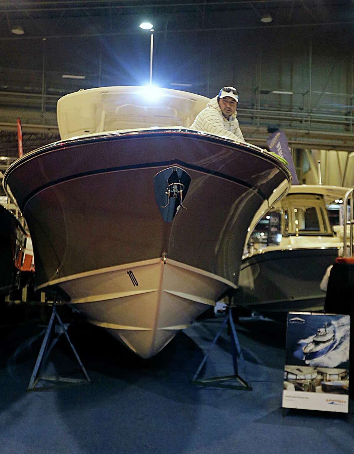 Malon Trigueros puts the finishing touches on a Grady White center console boat in the MarineMax booth during setup for The Houston International Boat, Sport & Travel Show Jan. 5, 2017, in Houston. ( James Nielsen / Houston Chronicle )