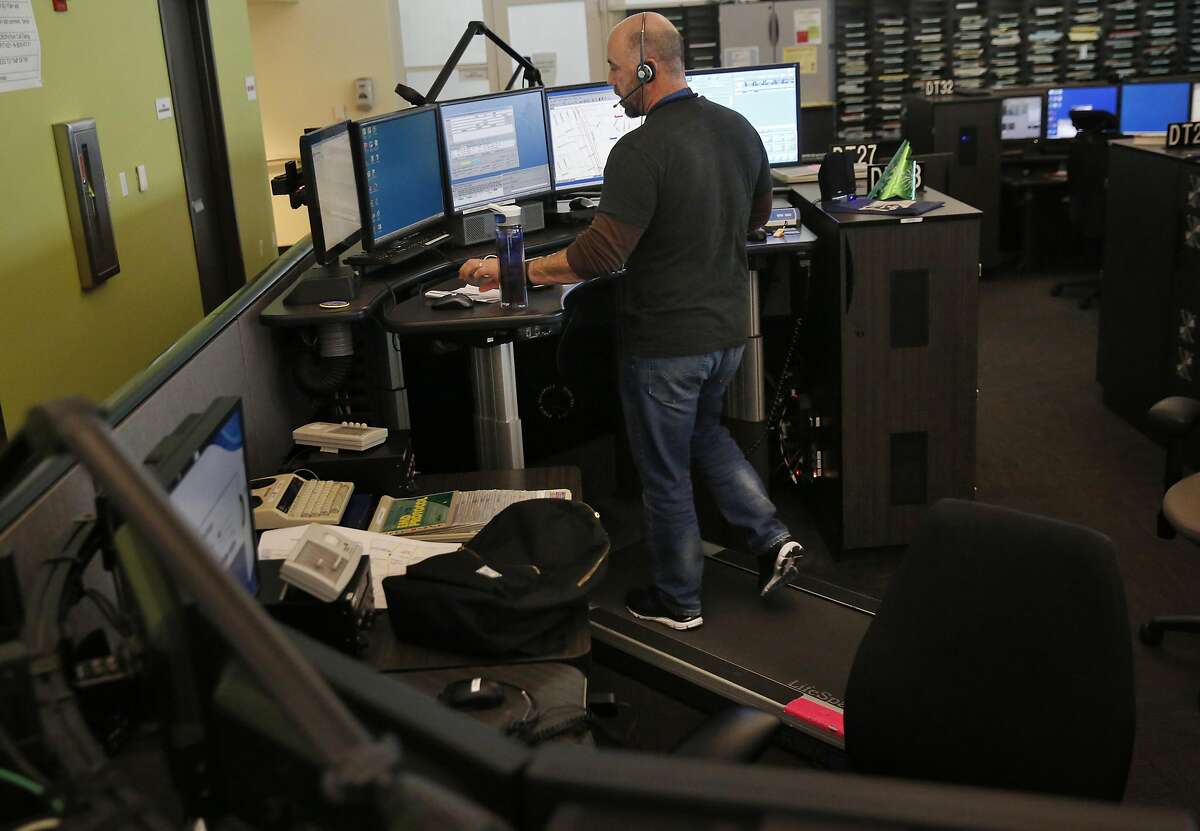 Ron Davis takes calls while walking on a treadmill and working overtime hours at the 911 dispatch center Jan. 6, 2017 in San Francisco, Calif.