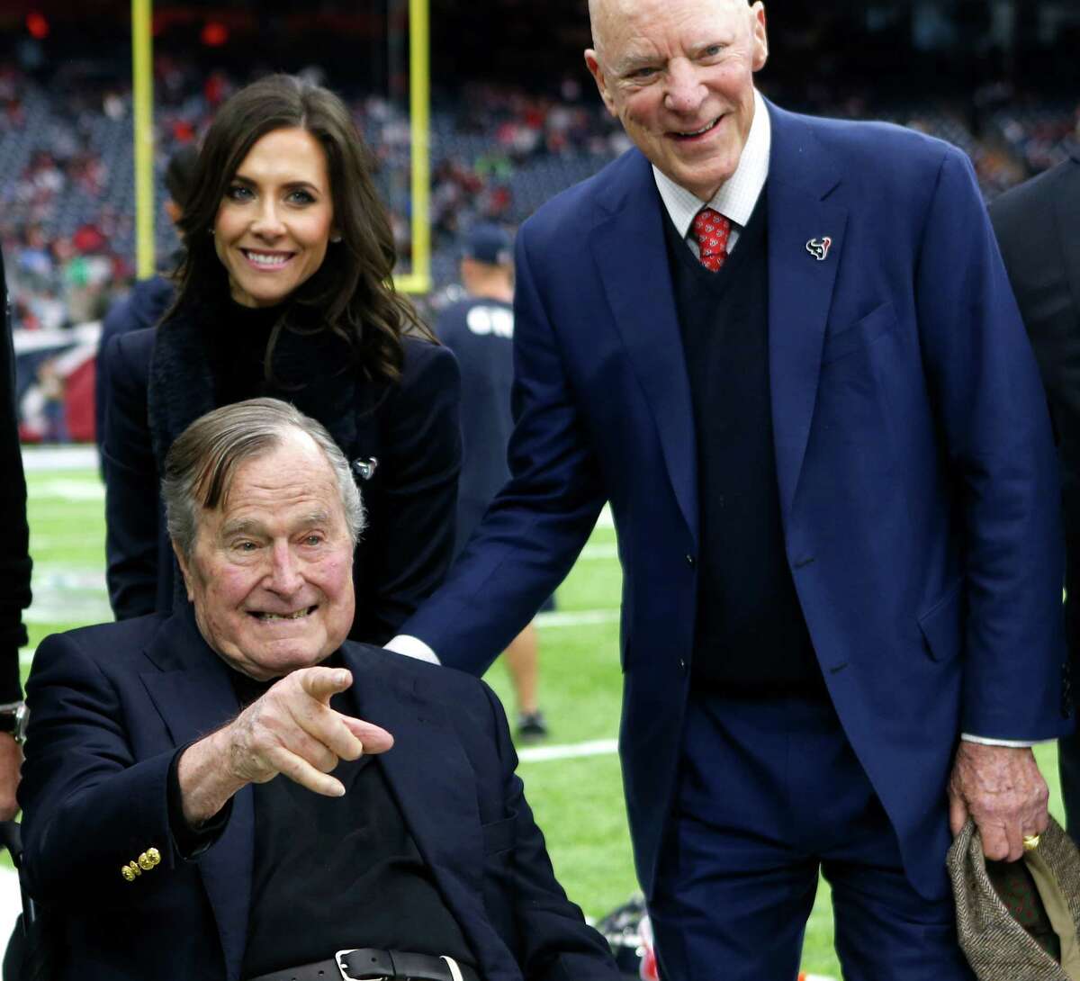 Former President George H. W. Bush, front-left, poses for a photo with Hannah McNair, rear-left, and Houston Texans owner Bob McNair, right, before an AFC Wild Card Playoff game at NRG Stadium on Saturday, Jan. 7, 2017, in Houston. Take a look back at the incredible political career of George H.W. Bush.
