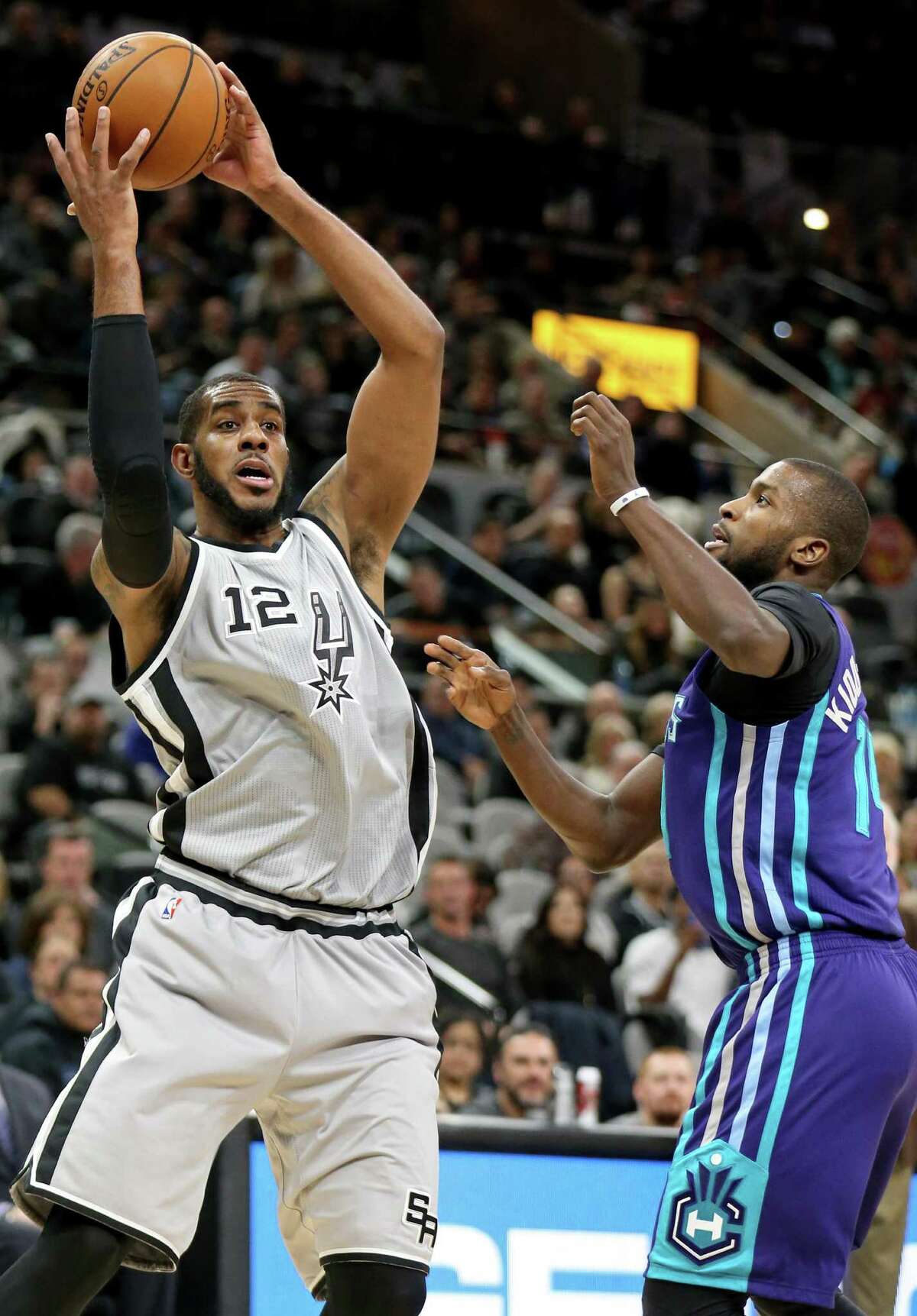 San Antonio Spurs' LaMarcus Aldridge looks to pass around Charlotte Hornets' Michael Kidd-Gilchrist during first half action Saturday Jan. 7, 2017 at the AT&T Center.