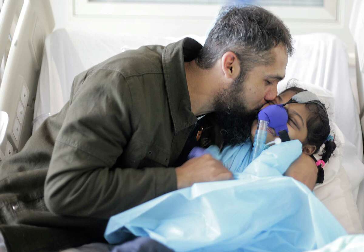 Maira Junaid, 9, sits in her Texas Children's hospital bed with her dad as she waits for her family to raise enough money for a lung transplant on Wednesday, Jan. 4, 2017, in Houston. Junaid's parents have been working with the hospital since one of her lungs collapsed due to cystic fibrosis. Her parents are trying to raise enough money so she can get on the donor list.