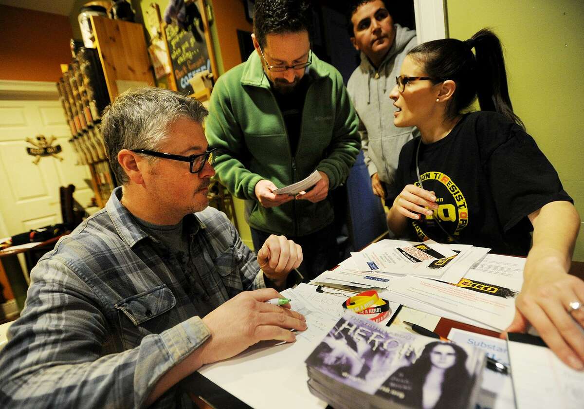 From left; John Emery, of Brookfield, and Dan Ladore, of Bethel, sign up on an email list with Julia Ambrosi, of Danbury, during a meeting of The Hero Project, raising awareness of heroin and opiod addiction, at Molten Java in Bethel, Conn. on Sunday, January 8, 2016.