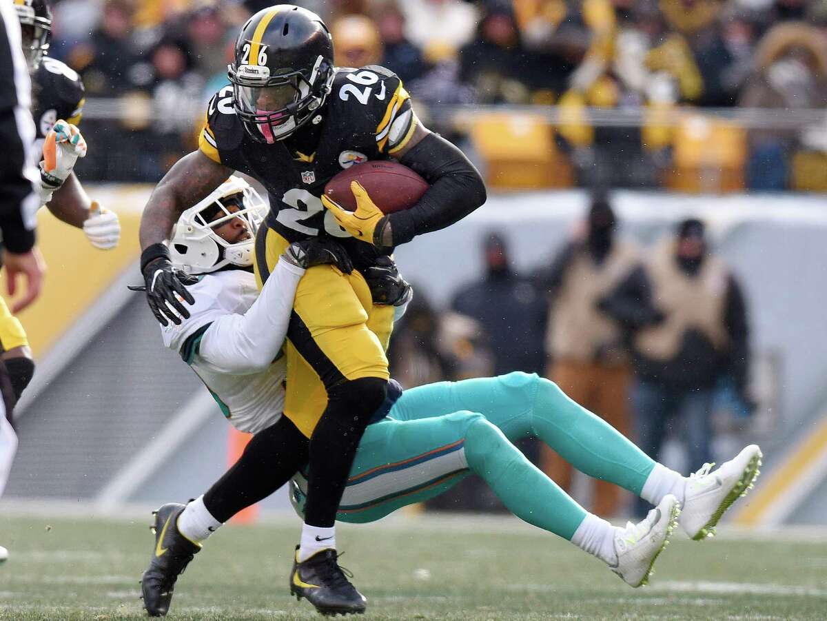 Pittsburgh Steelers running back Le'Veon Bell (26) runs throw a tackle by Miami Dolphins free safety Bacarri Rambo (30) during the first half of an AFC Wild Card NFL football game in Pittsburgh, Sunday, Jan. 8, 2017. (AP Photo/Don Wright)