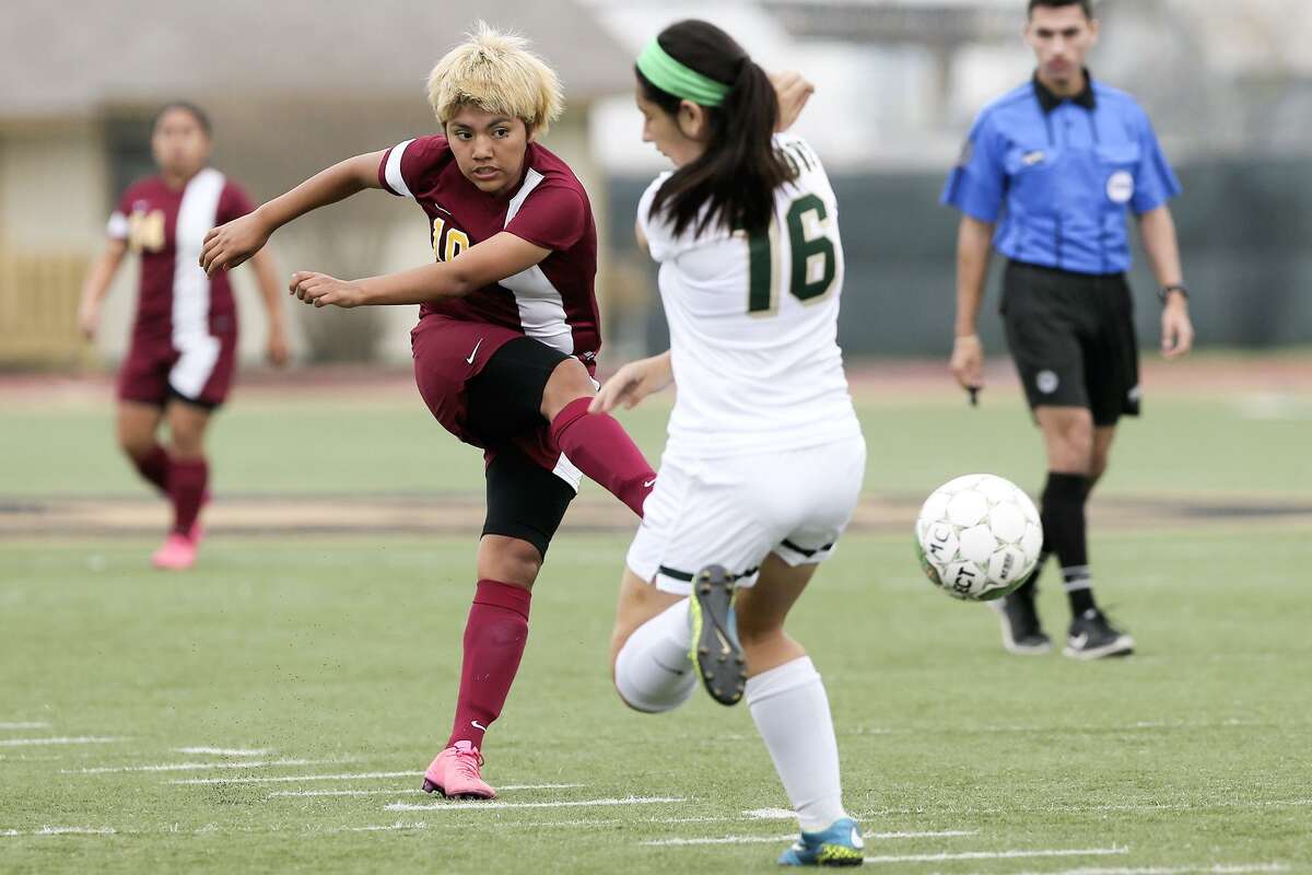 Harlandale’s Jazmin Baltazar (center left) kicks the ball past McCollum’s Joana Villarreal during their District 28-5A game at Harlandale Memorial Stadium on March 17, 2016.