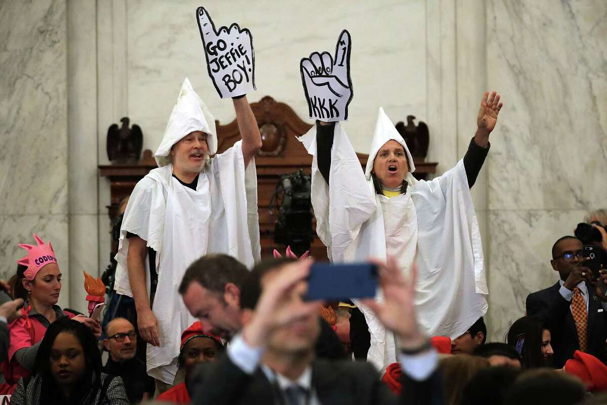 Protesters wearing white sheets shout at Sen. Jeff Sessions (R-AL) as he arrives for his confirmation hearing to be the U.S. attorney general Senate Judiciary Committee in the Russell Senate Office Building on Capitol Hill January 10, 2017 in Washington, DC. Sessions was one of the first members of Congress to endorse and support President-elect Donald Trump, who nominated him for Attorney General.