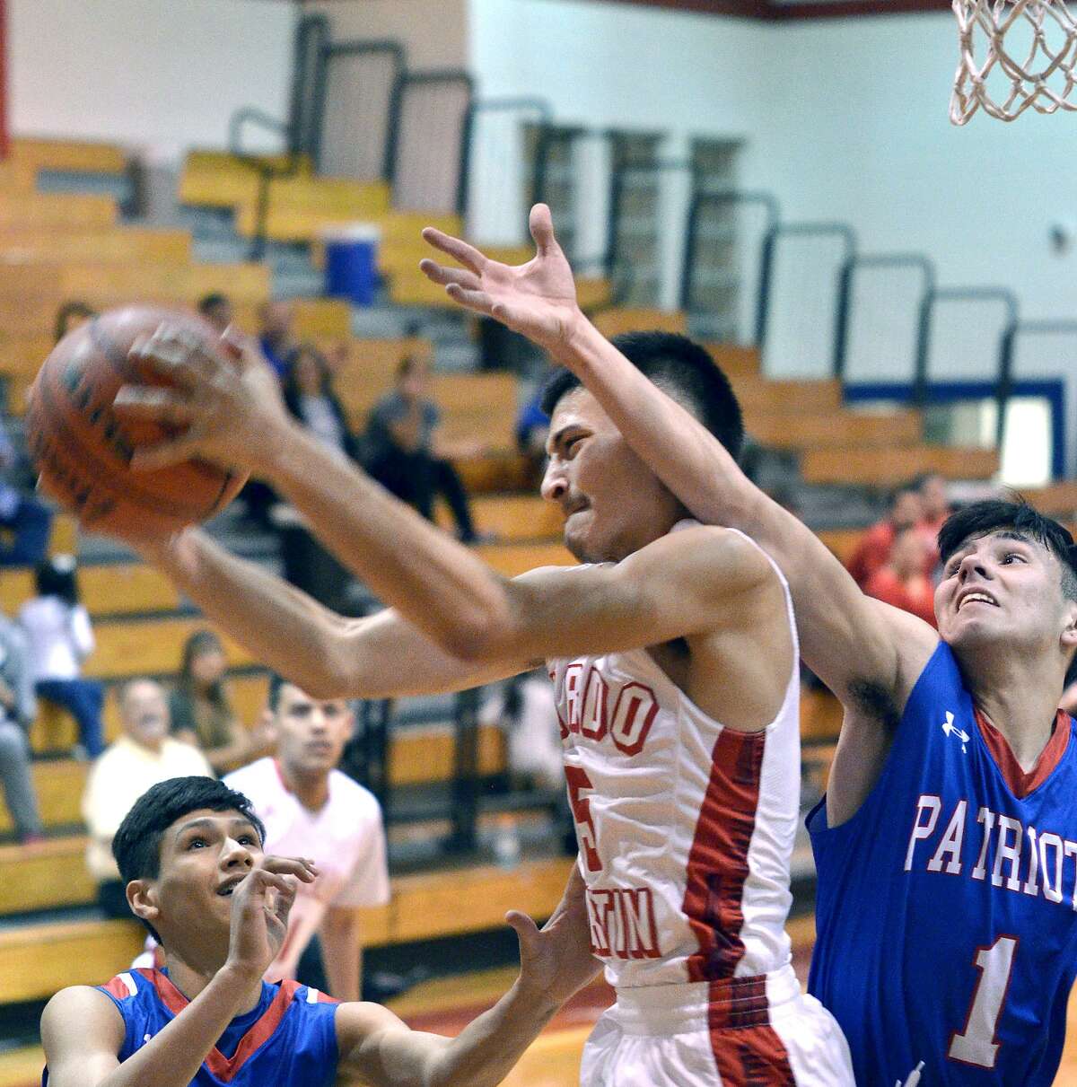 Jaime Garcia battles a pair of Veterans Memorial defenders as rebounds the ball for the Tigers Tuesday at Martin.