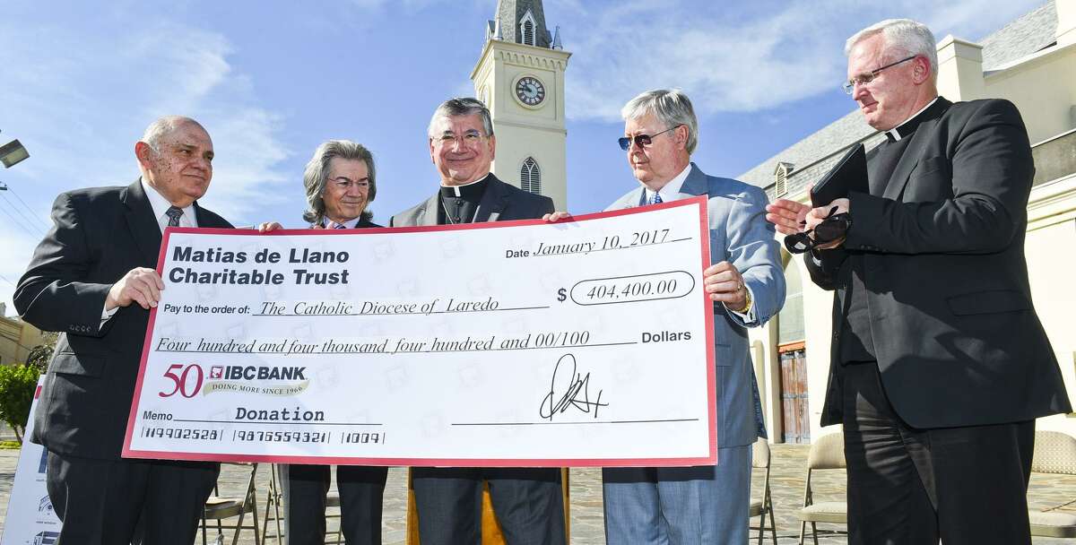 Larry Norton, Doug Howland, Bishop James Tamayo, IBC-Laredo CEO Dennis Nixon and Monsignor James Harris pose for a photo with a $404,400 check donated to the Catholic Diocese of Laredo from the Matias de Llano Charitable Trust on Tuesday afternoon outside San Agustin Cathedral.