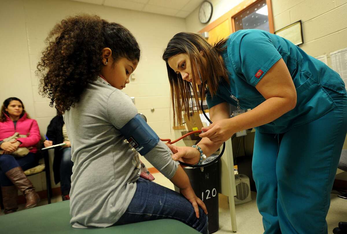 New kindergarten student Julieth Ramos, 6, has her blood pressure taken by medical assistant Jarely Rodriguez as part of a physical exam at the Optimus Health Care School Based Health Center at Barnum-Waltersville School in Bridgeport, Conn. on Tuesday, January 10, 2016. The company operates 17 SBHCs in the city including the newly-licensed center at Jettie Tisdale Elementary School.