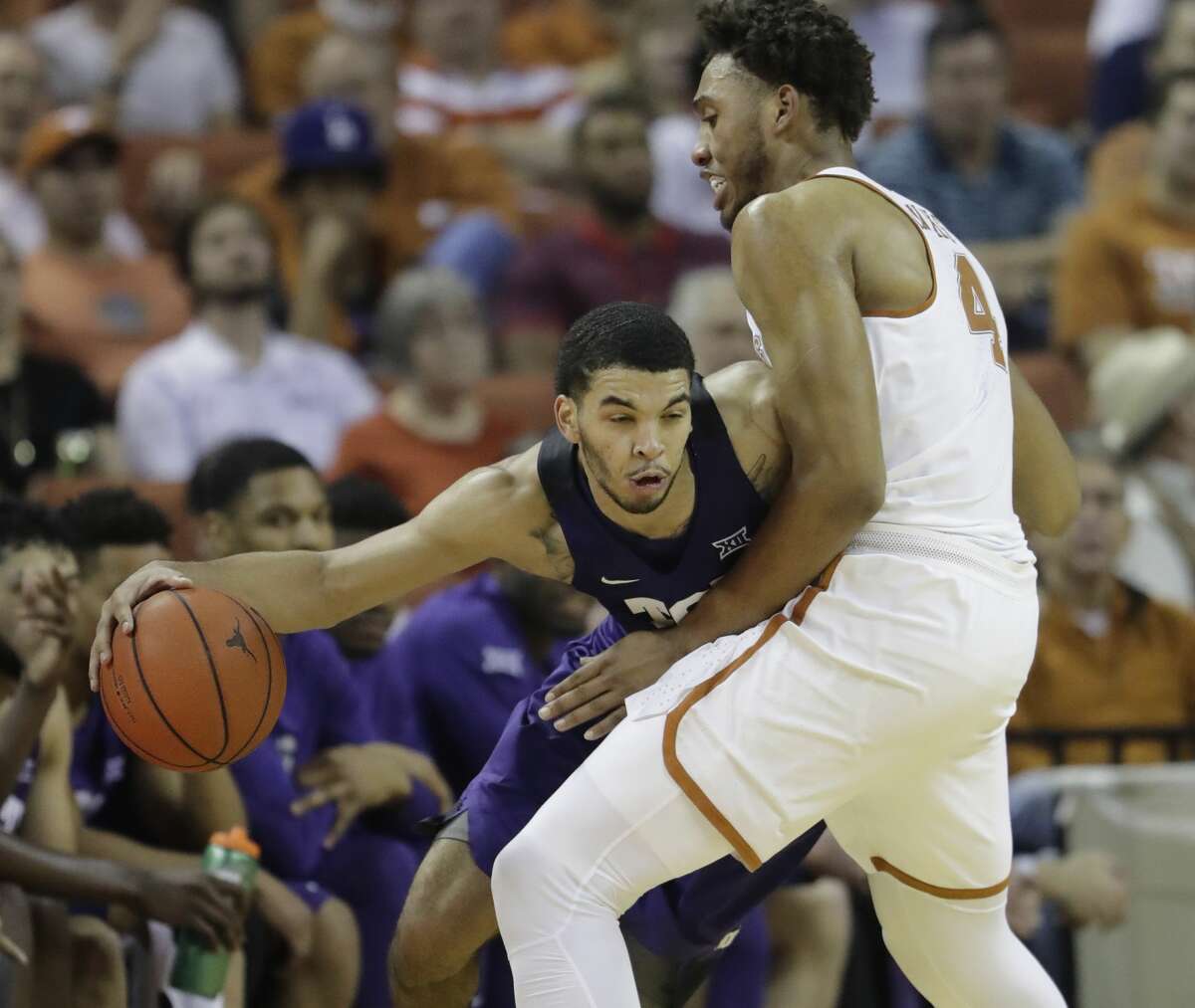 TCU guard Kenrich Williams, left, drives around Texas center James Banks (4) during the second half of an NCAA college basketball game, Wednesday, Jan. 11, 2017, in Austin, Texas. TCU won 64-61.(AP Photo/Eric Gay)